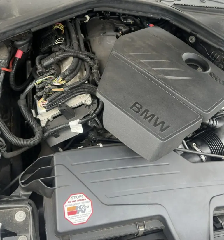 BMW 1 Series engine bay with the ECU being removed to read the ISN code